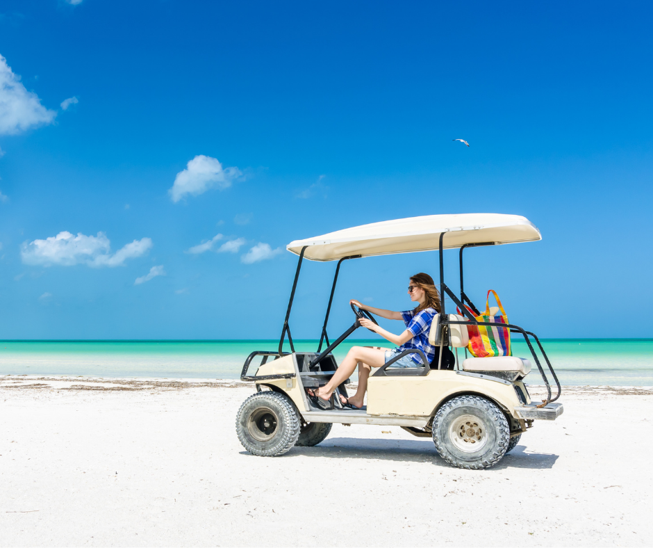 Person driving a golf cart one the beach, representing golf cart insurance.